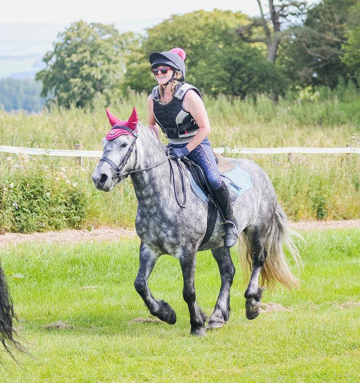grey pony  cantering during a fun ride